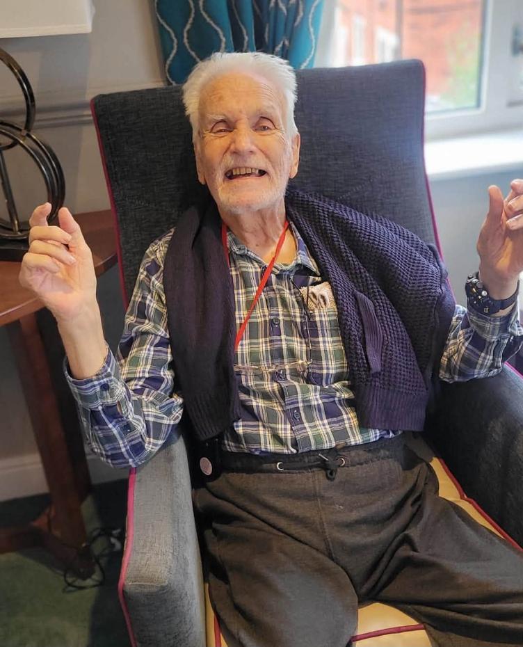 older man in a chair smiling